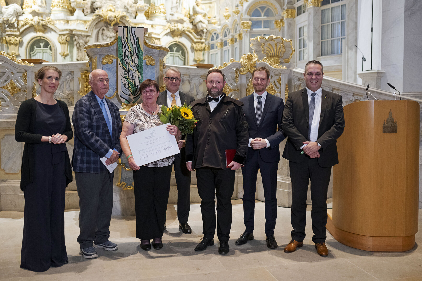 Männer und Frauen stehen vor einem Altar.