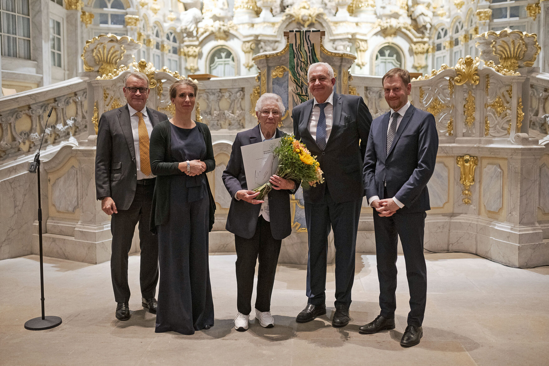 Männer und Frauen stehen vor einem Altar.