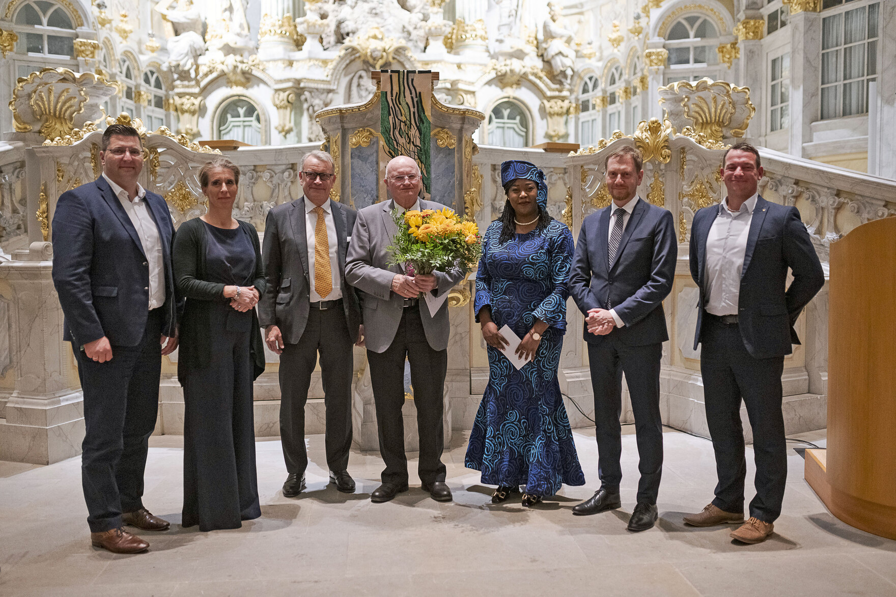 Männer und Frauen stehen vor einem Altar.